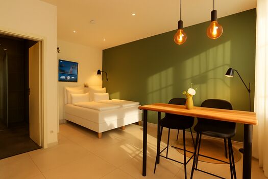 Ihre moderne Basis in Pforzheim: Sauber, Praktisch, Stressfrei. Das Apartment Rubin Nr. 3 bietet die perfekte Kombination aus Privatsphäre und Funktionalität. Speziell auf die Bedürfnisse von Berufstätigen zugeschnitten, besticht es durch: • Ausstattung: Voll möblierter Wohn-/Schlafraum mit Smart-TV und viel Stauraum. • Selbstversorgung: Integrierte Küchenzeile (inkl. Kochfeld, Mikrowelle und Kühlschrank) für maximale Unabhängigkeit. • Komfort: Eigenes modernes Badezimmer mit Dusche/WC; Bettwäsche und Handtücher inklusive. • Konnektivität: Schnelles WLAN für reibungsloses Arbeiten oder Streamen im Feierabend. Die ideale Wahl für Monteure, die eine gepflegte Atmosphäre und eine zentrale Anbindung schätzen. Ihre moderne Basis in Pforzheim: Sauber, Praktisch, Stressfrei. Das Apartment Rubin Nr. 3 bietet die perfekte Kombination aus Privatsphäre und Funktionalität. Speziell auf die Bedürfnisse von Berufstätigen zugeschnitten, besticht es durch: • Ausstattung: Voll möblierter Wohn-/Schlafraum mit Smart-TV und viel Stauraum. • Selbstversorgung: Integrierte Küchenzeile (inkl. Kochfeld, Mikrowelle und Kühlschrank) für maximale Unabhängigkeit. • Komfort: Eigenes modernes Badezimmer mit Dusche/WC; Bettwäsche und Handtücher inklusive. • Konnektivität: Schnelles WLAN für reibungsloses Arbeiten oder Streamen im Feierabend. Die ideale Wahl für Monteure, die eine gepflegte Atmosphäre und eine zentrale Anbindung schätzen.