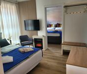 Blick auf Wohnzimmer mit einem Schlafsofa 160*200 und Schlafzimmer mit einem Boxspringbett 160*200r Blick auf Wohnzimmer mit einem Schlafsofa 160*200 und Schlafzimmer mit einem Boxspringbett 160*200r