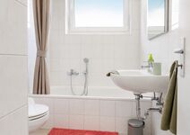 Bad im EG & 1. OG: Das Badezimmer verfügt über einen kleinen Mülleimer sowie eine Duschmatte vor der Badewanne. Ein großes Fenster sorgt für optimale Belüftung, während ein Rollo Privatsphäre bietet. Die Badewanne kann auch als Dusche genutzt werden. Bad im EG & 1. OG: Das Badezimmer verfügt über einen kleinen Mülleimer sowie eine Duschmatte vor der Badewanne. Ein großes Fenster sorgt für optimale Belüftung, während ein Rollo Privatsphäre bietet. Die Badewanne kann auch als Dusche genutzt werden.