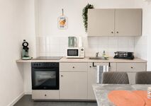 Küche im EG: Die moderne Küchenzeile in Beige verfügt über Backofen mit Ceranfeld, Mikrowelle, Spülbecken, Kaffeemaschine, Wasserkocher, Abtropfgestell, Trockentücher und ausreichend Arbeitsfläche zur Speisenzubereitung. Küche im EG: Die moderne Küchenzeile in Beige verfügt über Backofen mit Ceranfeld, Mikrowelle, Spülbecken, Kaffeemaschine, Wasserkocher, Abtropfgestell, Trockentücher und ausreichend Arbeitsfläche zur Speisenzubereitung.
