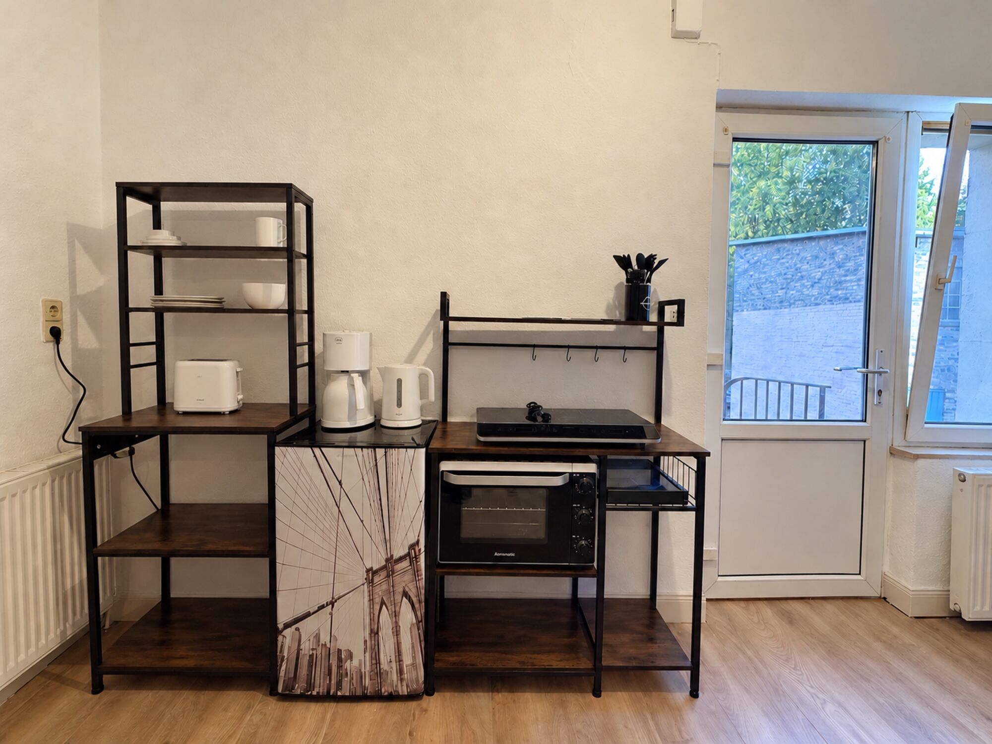 Kühlschrank, Kochgelegenheit mit Backofen und Regale sowie Eingangstür der Wohnung Kühlschrank, Kochgelegenheit mit Backofen und Regale sowie Eingangstür der Wohnung