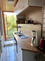 Küche mit zwei Induktionskochfeldern, Geschirrspüler, Kühlschrank sowie Kombigerät mit Mikrowellen-, Back-, Grill- und Airfry-Funktion. Küche mit zwei Induktionskochfeldern, Geschirrspüler, Kühlschrank sowie Kombigerät mit Mikrowellen-, Back-, Grill- und Airfry-Funktion.