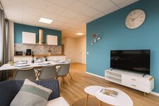 Wohnzimmer mit Fernseher, Esstisch, voll ausgestatteter Küche Wohnzimmer mit Fernseher, Esstisch, voll ausgestatteter Küche