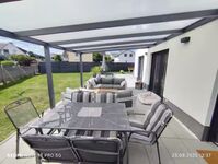 Überdachte Terrasse mit Grill und Sitzgarnitur Überdachte Terrasse mit Grill und Sitzgarnitur