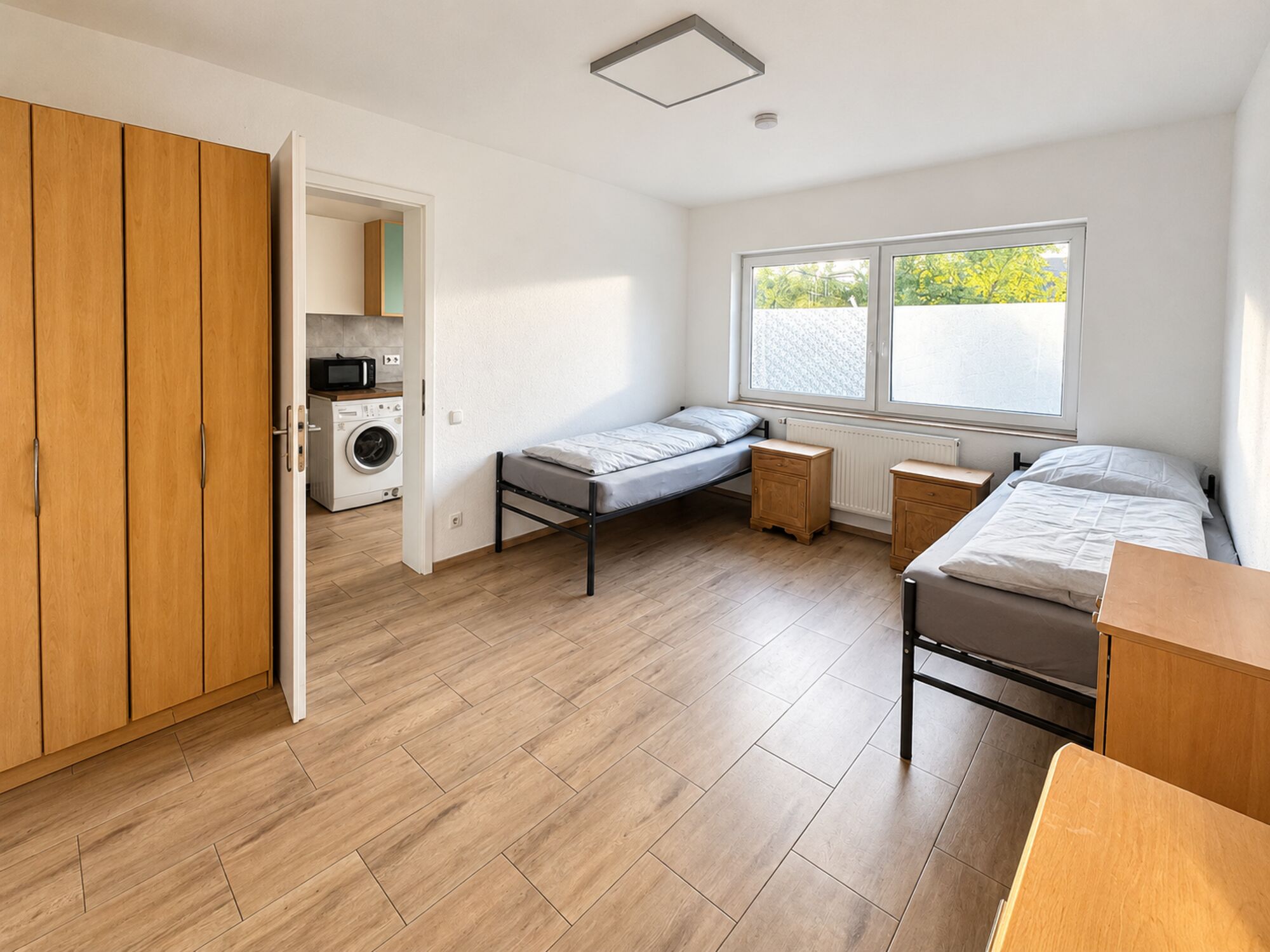 Helles Zimmer mit getrennten Betten, Schrank und Zugang zur Küche Helles Zimmer mit getrennten Betten, Schrank und Zugang zur Küche