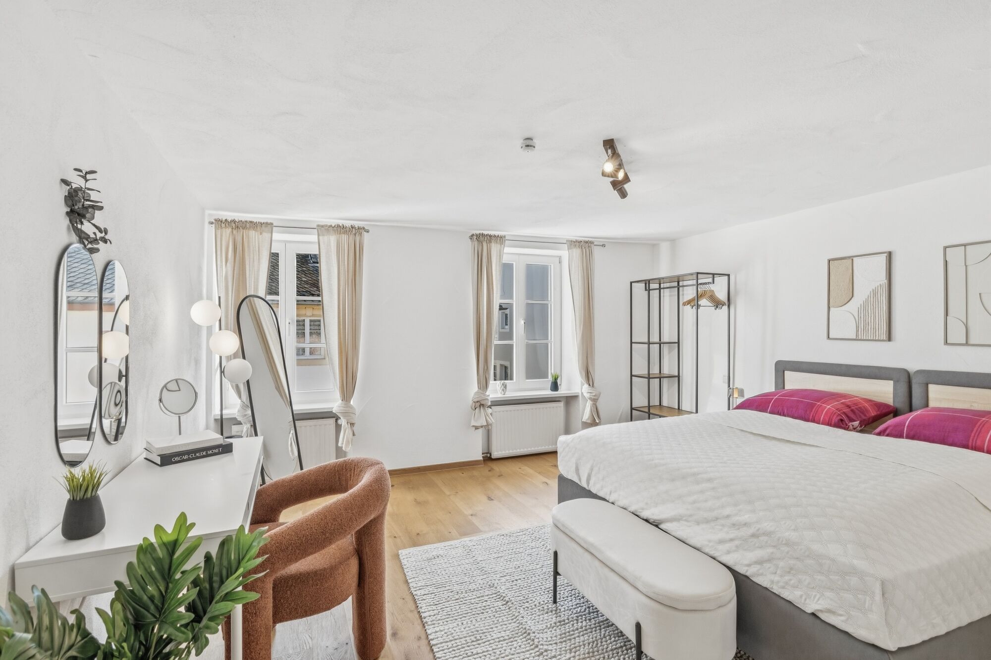 Helles Zimmer mit Doppelbett, braunem Ledersessel und Fenster mit Blick nach außen. Helles Zimmer mit Doppelbett, braunem Ledersessel und Fenster mit Blick nach außen.