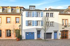 Historisches dreistöckiges Stadthaus mit blauen Fensterläden und blauer Garagentür auf gepflastertem Historisches dreistöckiges Stadthaus mit blauen Fensterläden und blauer Garagentür auf gepflastertem
