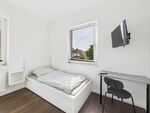 Blick auf ein Einzelbett mit Fernseher und Tisch Blick auf ein Einzelbett mit Fernseher und Tisch