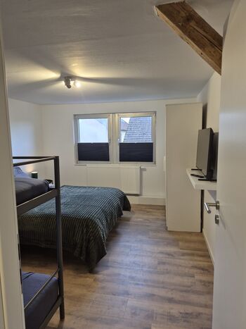 Schlafzimmer mit Doppelbett und Etagenbett, Schrank und TV Schlafzimmer mit Doppelbett und Etagenbett, Schrank und TV