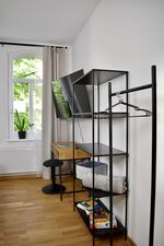 Zimmer 1: Zeigt den eingerichteten Arbeitsplatz mit einem darüber montierten Flachbildfernseher. Ein offenes Regal und eine Kleiderstange mit Bügeln bieten stilvolle und praktische Aufbewahrungsmöglichkeiten für Ihre Kleidung. Zimmer 1: Zeigt den eingerichteten Arbeitsplatz mit einem darüber montierten Flachbildfernseher. Ein offenes Regal und eine Kleiderstange mit Bügeln bieten stilvolle und praktische Aufbewahrungsmöglichkeiten für Ihre Kleidung.