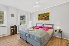 Zwei Einzelbetten zusammengestellt, großes Fenster mit Grünblick, buntes Moosgemälde, heller Holzbod Zwei Einzelbetten zusammengestellt, großes Fenster mit Grünblick, buntes Moosgemälde, heller Holzbod