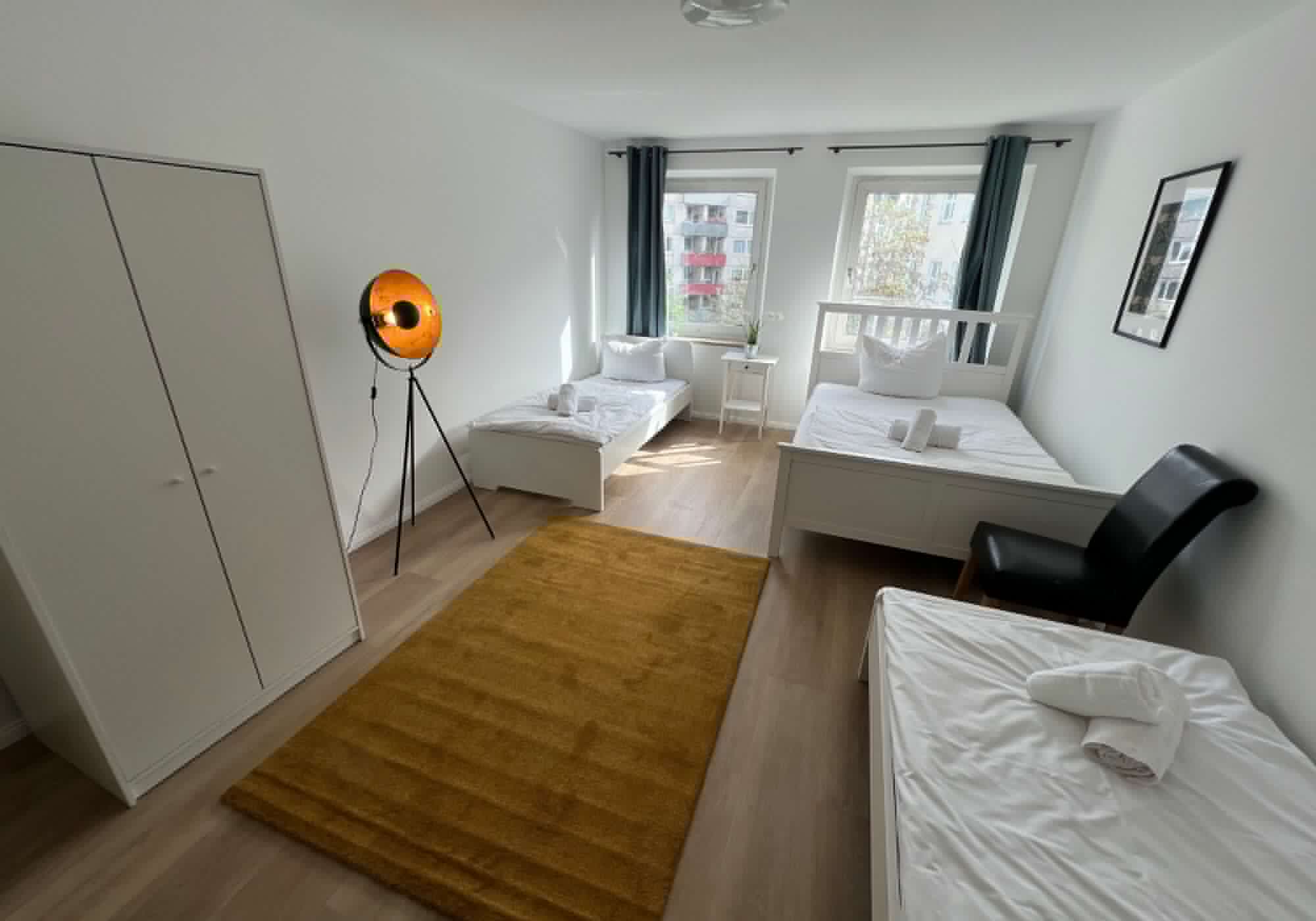 Schlafzimmer mit Doppelbett und zwei Einzelbetten