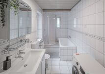 Badezimmer mit Dusche, Badewanne, WC und Waschmaschine