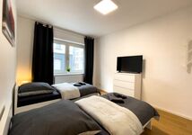 Schlafzimmer mit Einzelbetten und Smart-TV