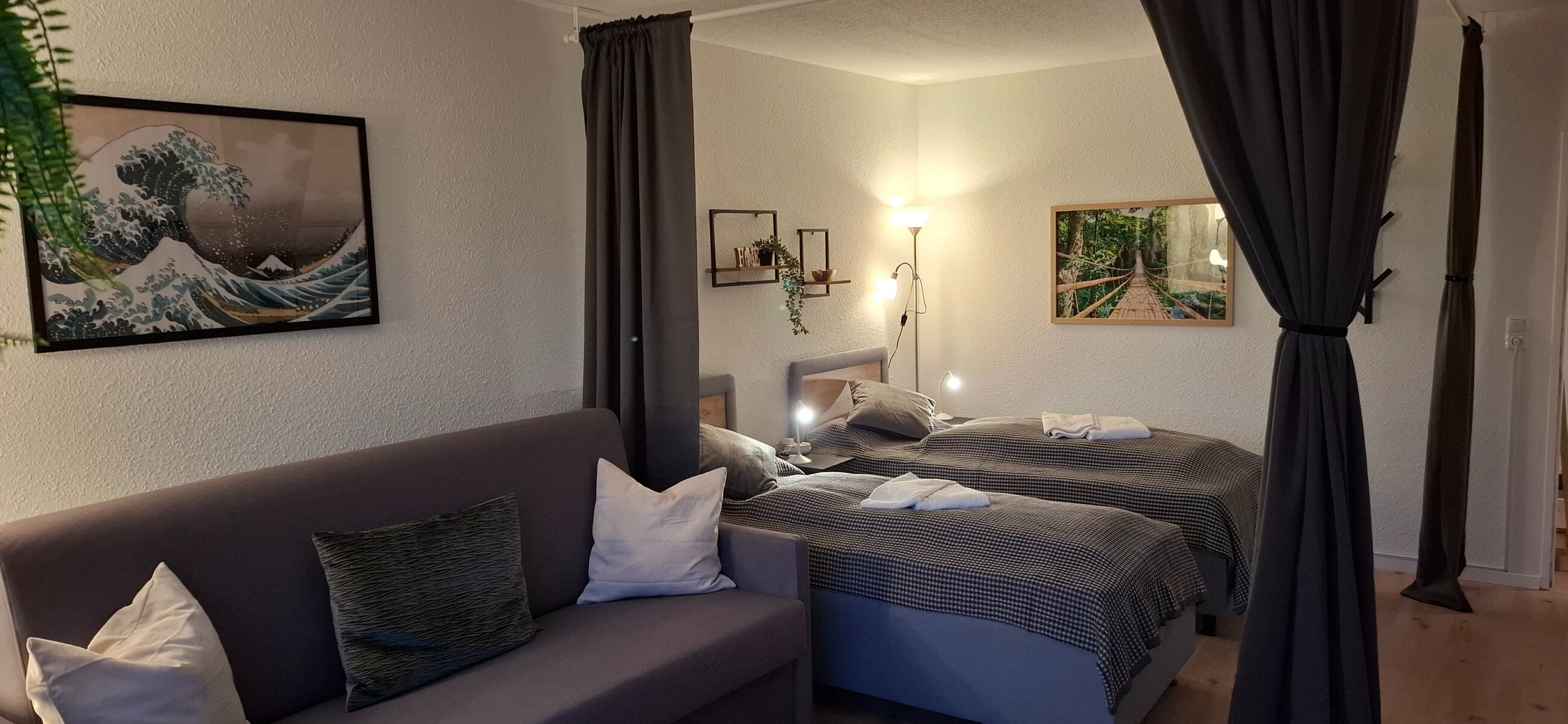 trennbares Wohn- und Schlafzimmer mit zwei Hotel-Boxspringbetten (zusammenschiebbar) sowie einer großen 160x200cm großen Schlafcouch. Davor der 55` große SmartTV
