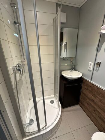 Badezimmer mit Dusche, Waschbecken und Toilette