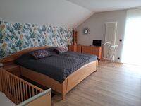 Schlafzimmer mit Doppelbett und Babybett