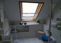 Badezimmer mit Dusche, WC, Föhn und Handtüchern