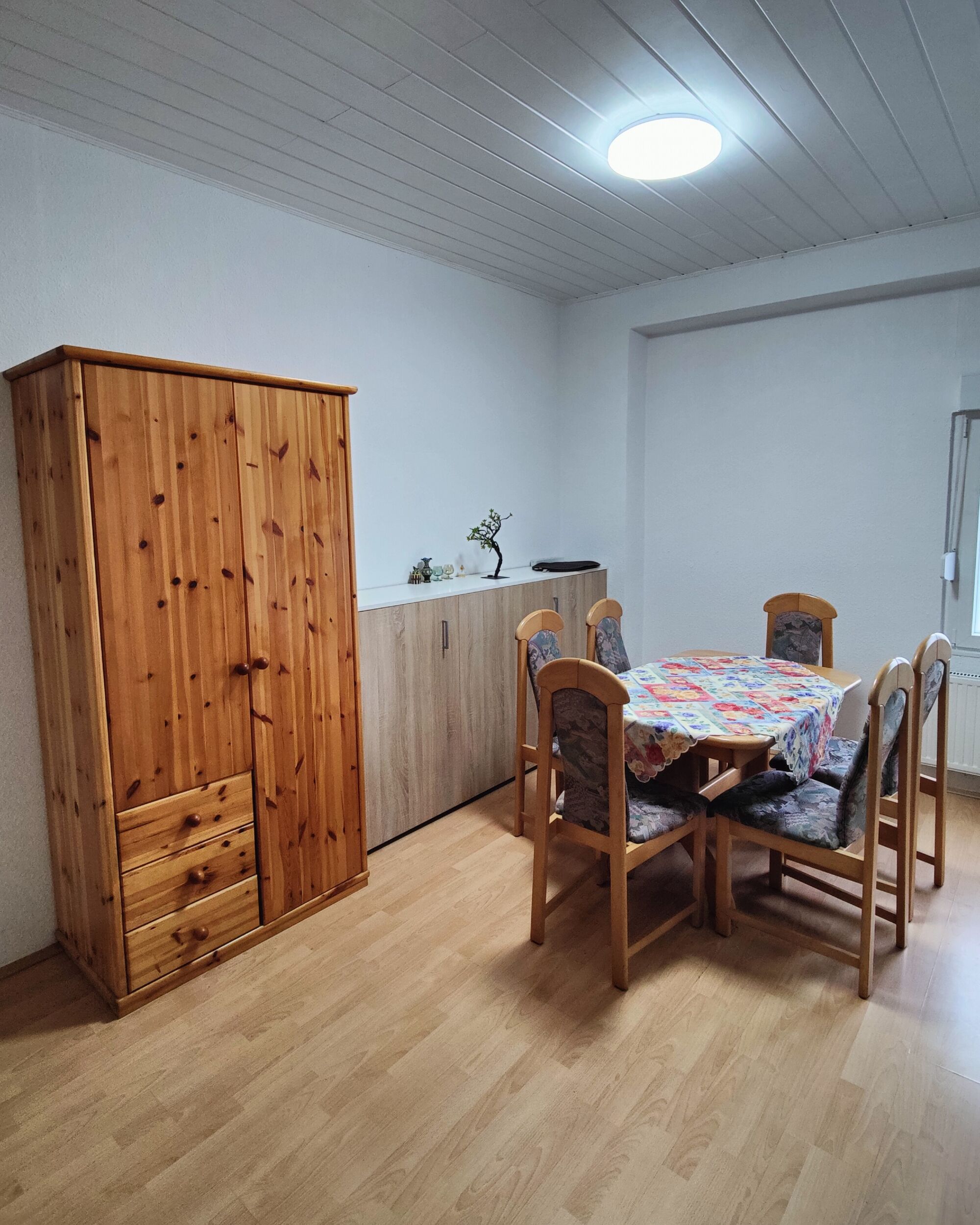 Zimmer 1: Schrank mit Esstisch und Komode