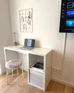 Heller Arbeitsplatz mit Schreibtisch, 50" TV und Zugang zur Terrasse.