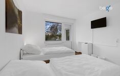 Schlafzimmer 1 mit zwei Einzelbetten, Sitzecke und Smart TV