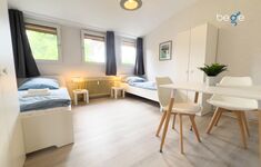 Schlafzimmer 1 mit zwei Einzelbetten, Sitzecke und Smart TV
