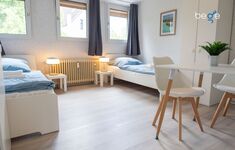 Schlafzimmer 1 mit zwei Einzelbetten, Sitzecke und Smart TV