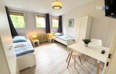 Schlafzimmer 1 mit zwei Einzelbetten, Sitzecke und Smart TV