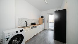 Küche mit Geschirrspüler, Waschmaschine und großen Kühlschrank