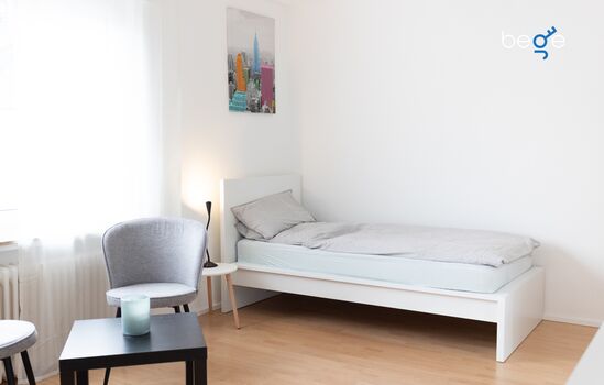 Schlafzimmer mit zwei Einzelbetten, Sitzecke und Smart TV