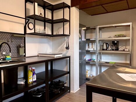Küche mit großem Kühlschrank, viel Stauraum und Edelstahl Arbeitsplatten