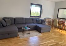 Wohnzimmer mit Schlafcouch und Reisebett