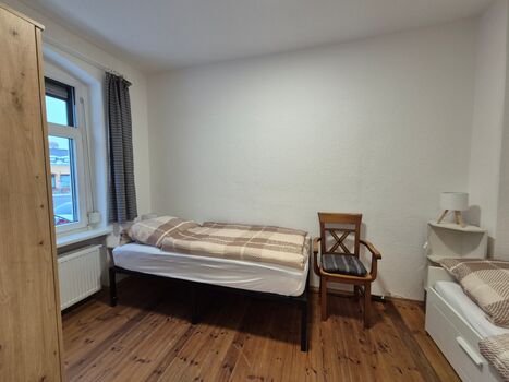 kleines Schlafzimmer mit 2 Betten und Kleiderschrank