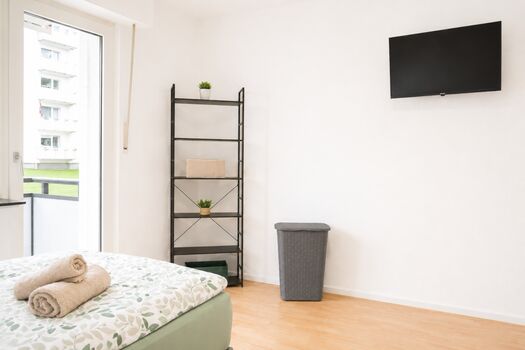 Ebenfalls hat dieser Schlafraum ein großes Kleiderregal, ein Smart-TV mit verstellbarer Wandhalterung und ein Wäschekorb. 