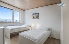 Schlafzimmer 2 mit zwei Einzelbetten, Sitzecke und Smart TV