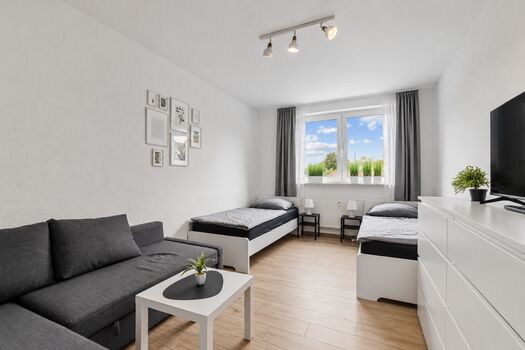 Helles Schlafzimmer mit gemütlichem Sofa für zusätzlichen Komfort und Entspannung.