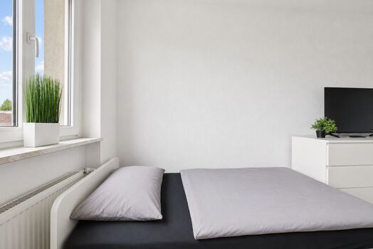 Schlafzimmer mit komfortablen Einzelbetten und Smart-TV für entspannte Abende.