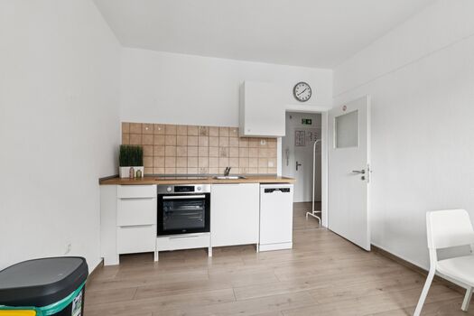 Voll ausgestattete Küche mit Spülmaschine, großem Kühlschrank und gemütlichem Sitzbereich.