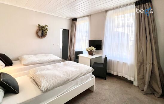 Heller Wohn- und Schlafbereich mit Smart-TV und Essplatz