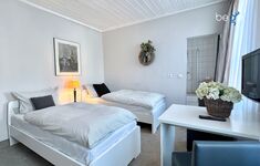 Heller Wohn- und Schlafbereich mit Smart-TV und Essplatz