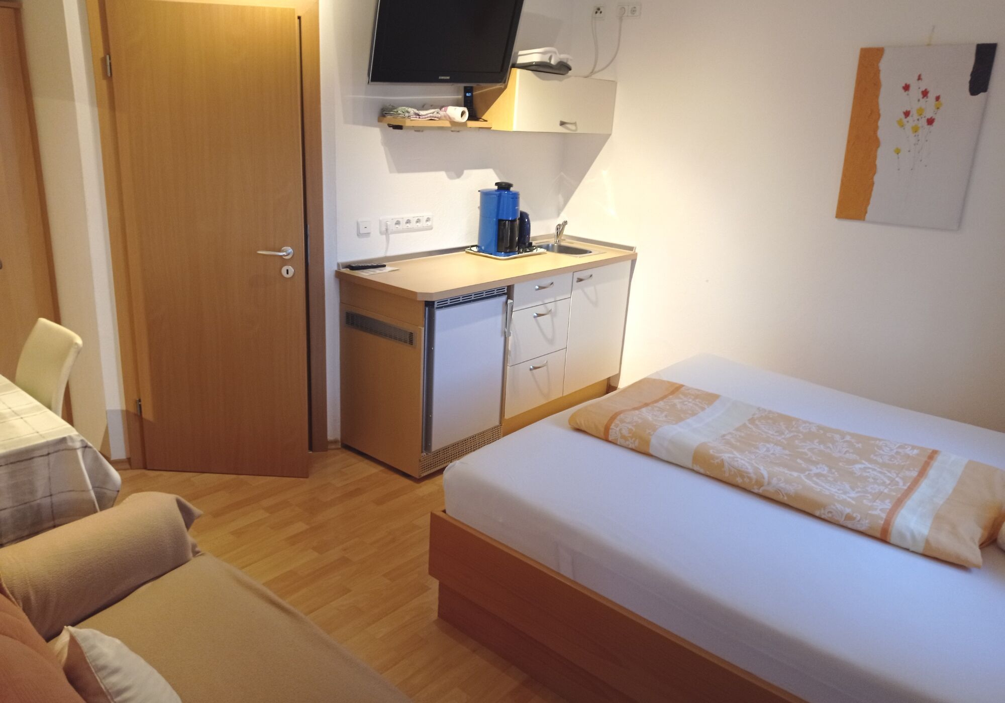 Schlafzimmer mit Miniküche und TV, Badezimmer 