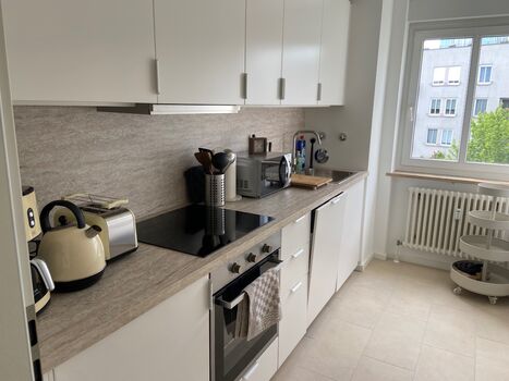 Komplett ausgestattete Küche mit Kühlschrank, Herd, Backofen, Mikrowelle, Kaffeemaschine, Toaster, Wasserkocher, Geschirr, Besteck, Teller, Gläser, Geschirrspülmaschine 