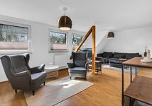 Wohnzimmer mit Couch, Sitzgelegenheiten und TV- DG Apartment