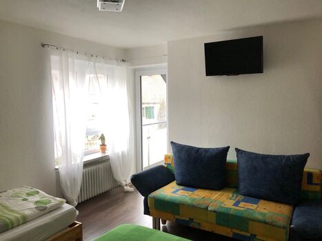 Großes Schlafzimmer mit TV und Balkonzugang