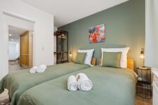 2-Bettzimmer mit Sitzbereich, als Einzel- oder Doppelbett möglich und Blick in den Flur