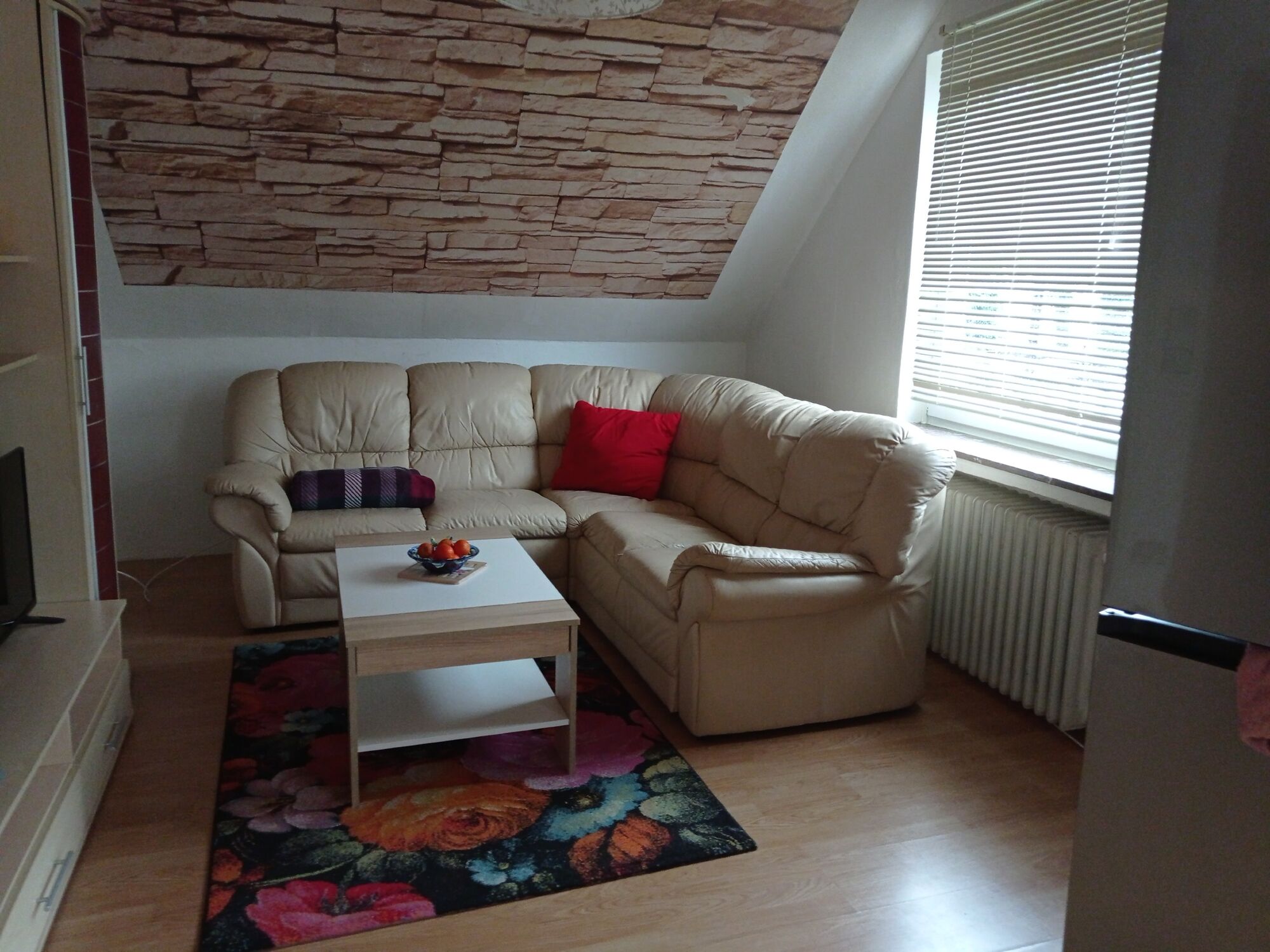 Großes Wohnzimmer mit Fernseher und Tisch mit Stühlen 