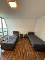 Helles Schlafzimmer mit zwei getrennten Betten und Fensterfront