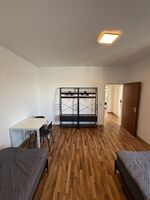 Praktisch eingerichtetes Monteurzimmer mit Garderobe und Sitzgelegenheiten