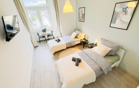 Schlafzimmer 1 mit zwei Einzelbetten, Sitzecke und Smart TV 