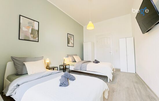 Schlafzimmer 1 mit zwei Einzelbetten, Sitzecke und Smart TV 